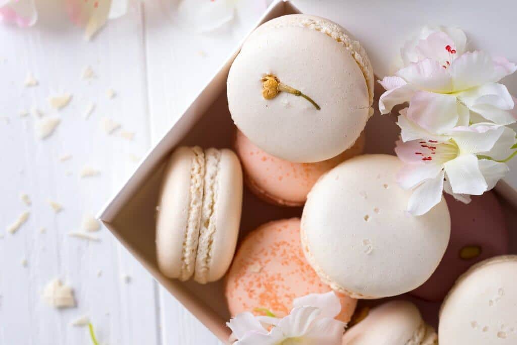 Close up colorful macarons dessert with vintage pastel tones on wooden background
