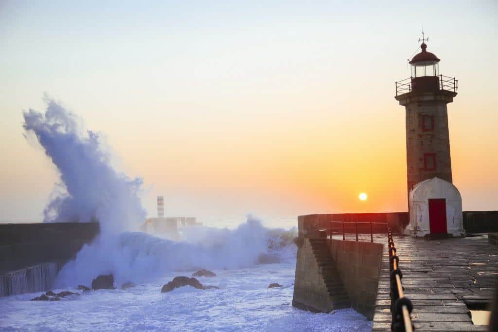 Lighthouse Felgueirasin Porto with wave splash at sunset, Porto, Portugal