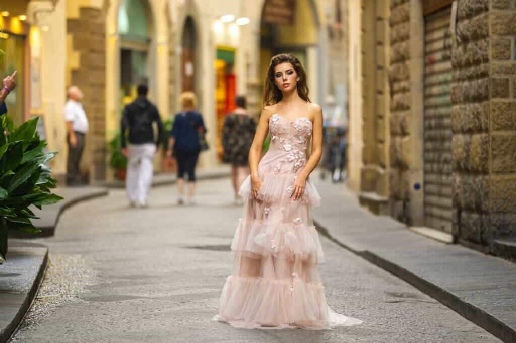 A bride in a pink wedding dress walks in Florence, Italy