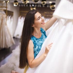 Happy bride chooses a dress in a wedding boutique