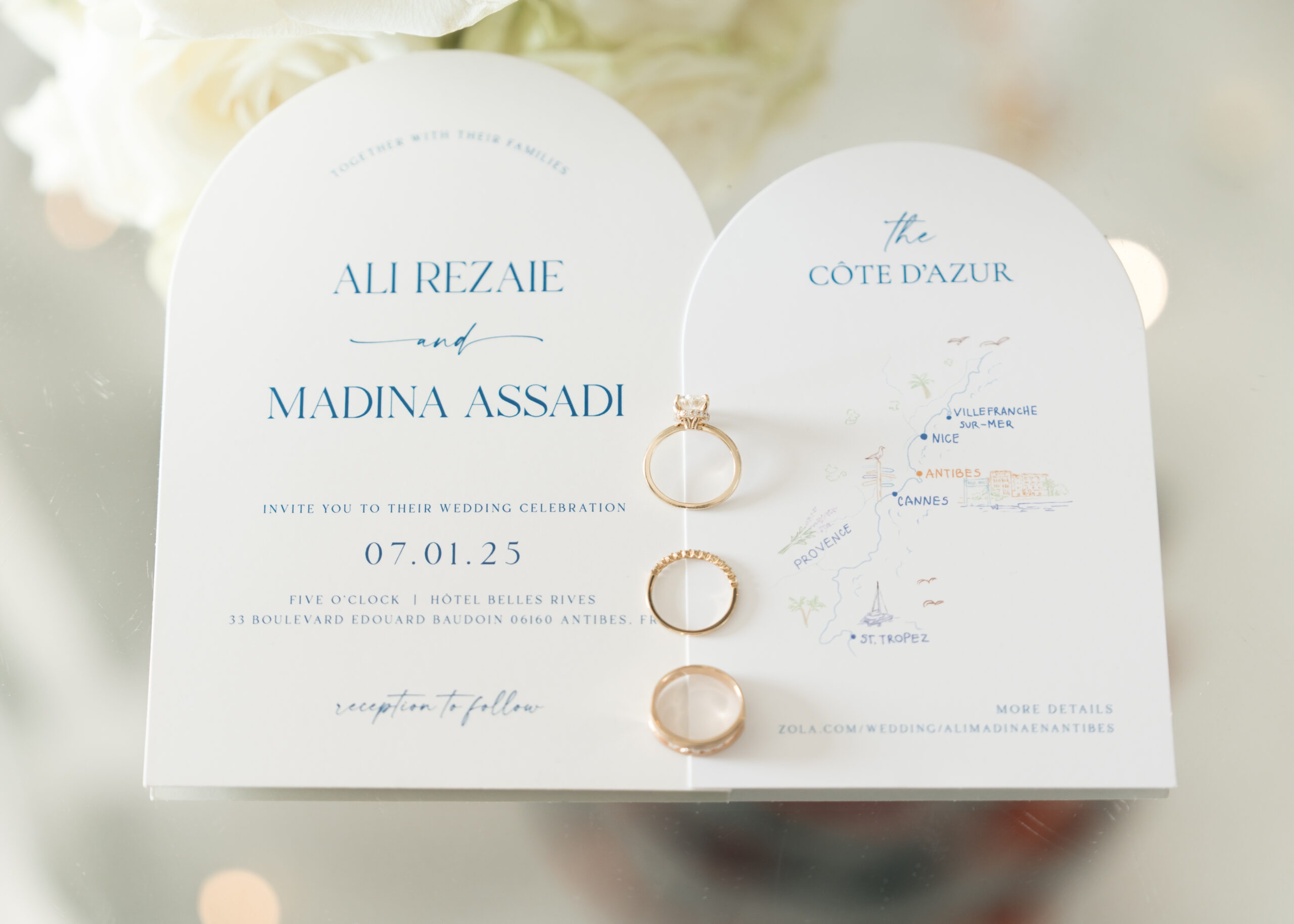 Arch-shaped wedding invitations with blue lettering and an illustrated Côte d’Azur map.