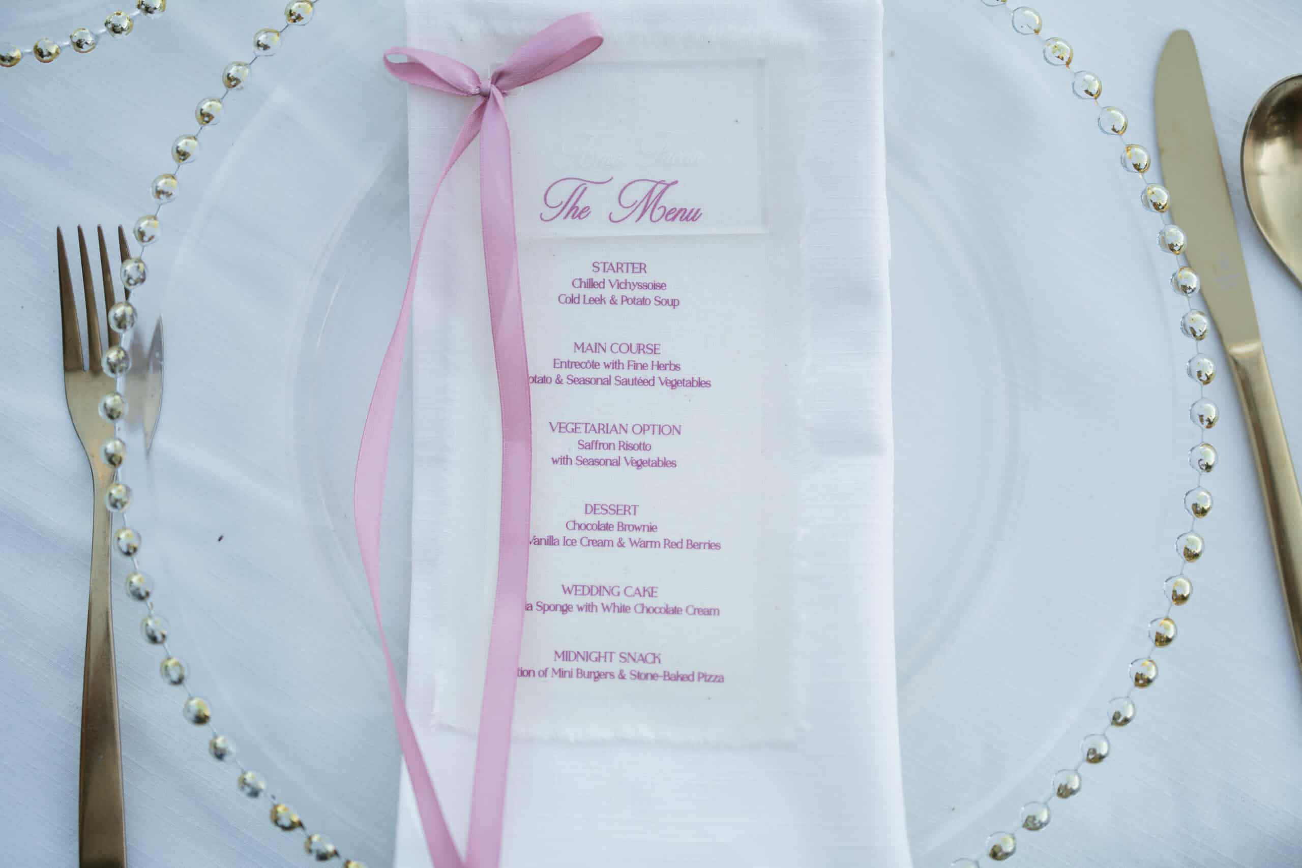 Wedding place setting at Son Togores with a pink ribbon, printed menu and beaded glass charger.